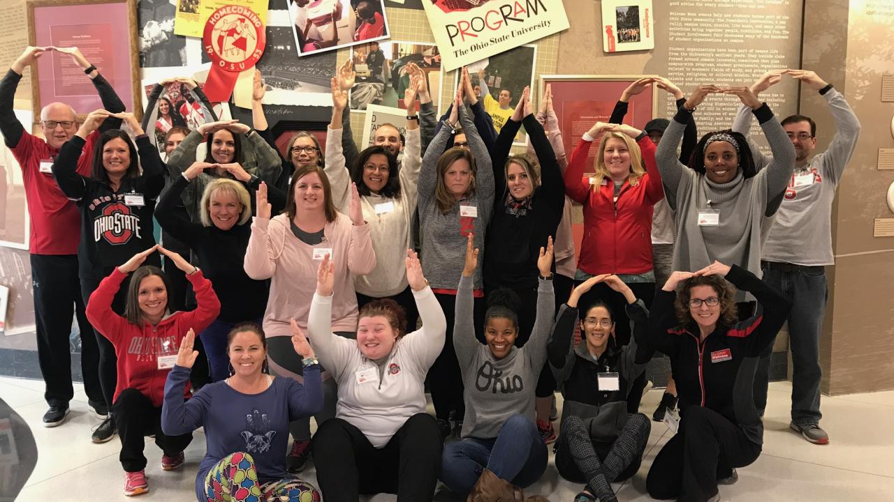 Group from 2019 of at least 20 employees form the O-H-I-O hand symbols